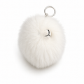 White fluffy pom-pom keychain on a white background
