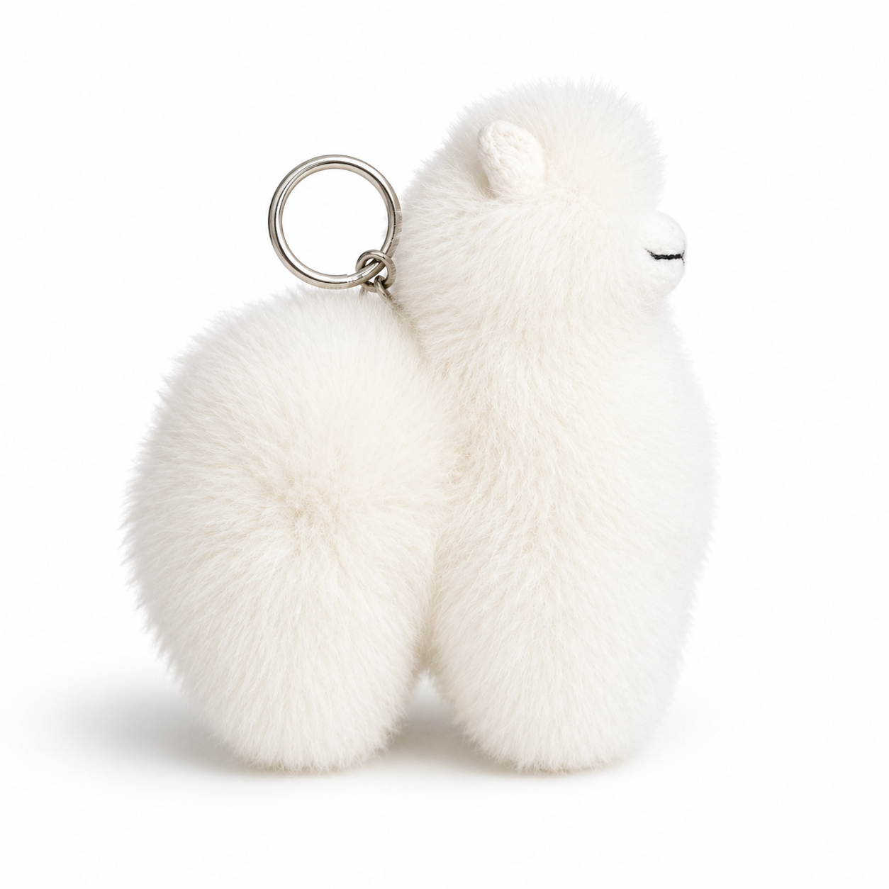 White fluffy keychain shaped like an alpaca on a white background